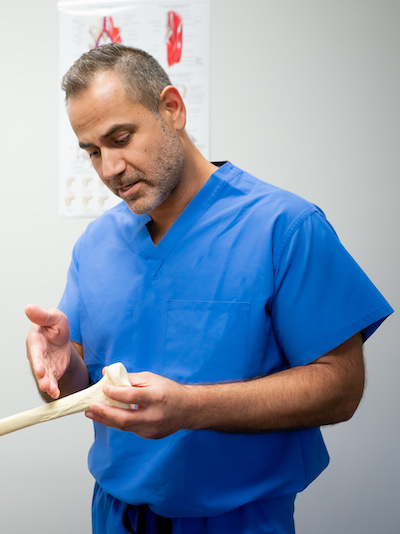 Dr. Hrayr Basmajian examining a femur model in his Upland clinic