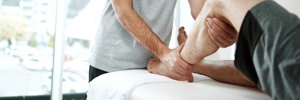 Man bending leg with the help of on-site therapist
